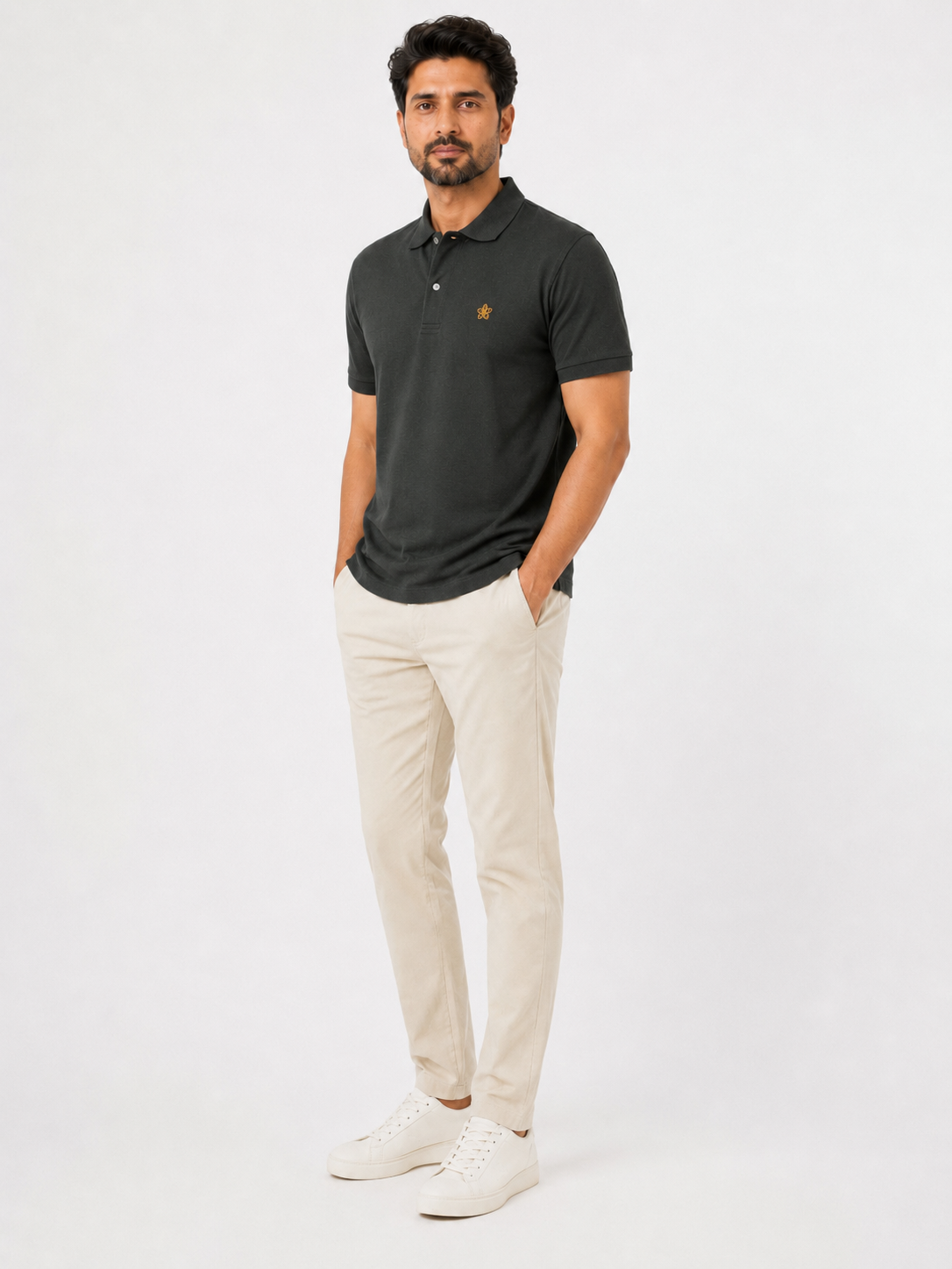 Man wearing a dark green polo shirt and beige pants on a white background