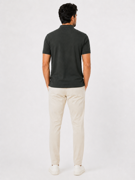 Man wearing a dark green polo shirt and beige pants on a white background
