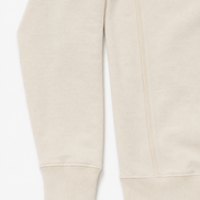 Close-up of sleeve of a cream sweatshirt on a white background