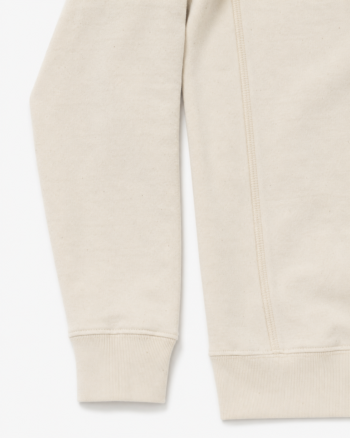 Close-up of sleeve of a cream sweatshirt on a white background