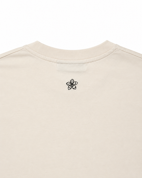 Cream t-shirt with a dark green embroidered Persimmon emblem design on a white background