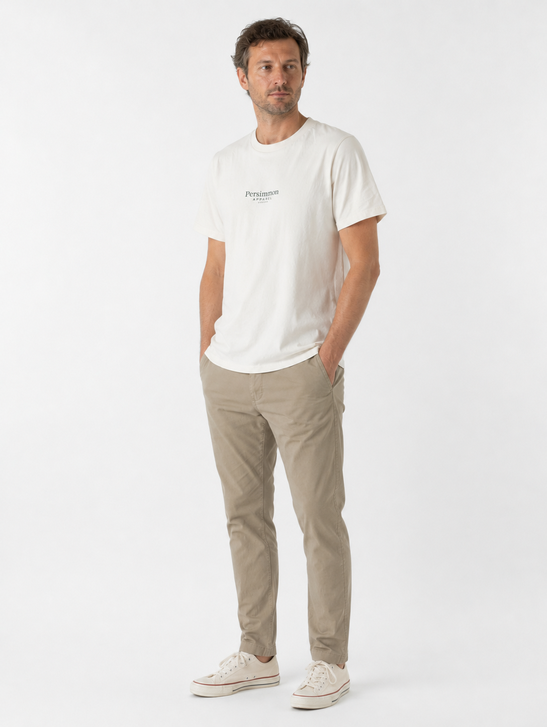 Man wearing a cream t-shirt and beige pants on a white background