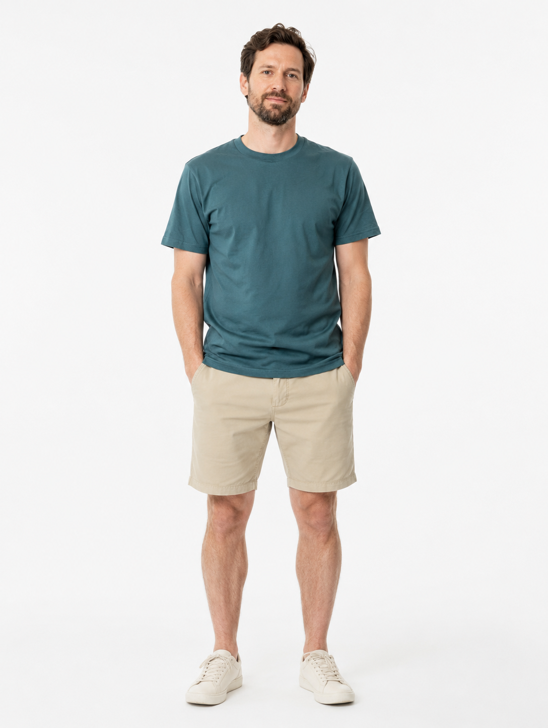 Man wearing a green  t-shirt and beige shorts on a white background