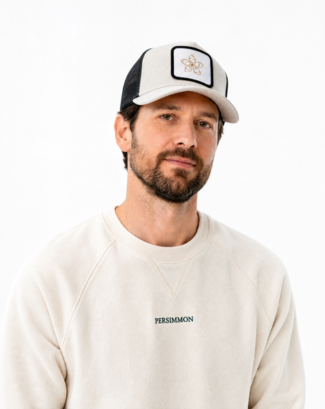 Man wearing a cap and a sweatshirt with 'Persimmon' branding on a white background