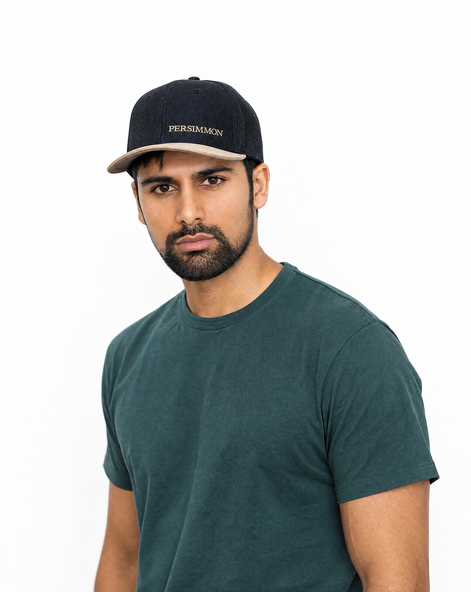 Man wearing a dark green t-shirt and black cap with 'Persimmon' branding on a white background
