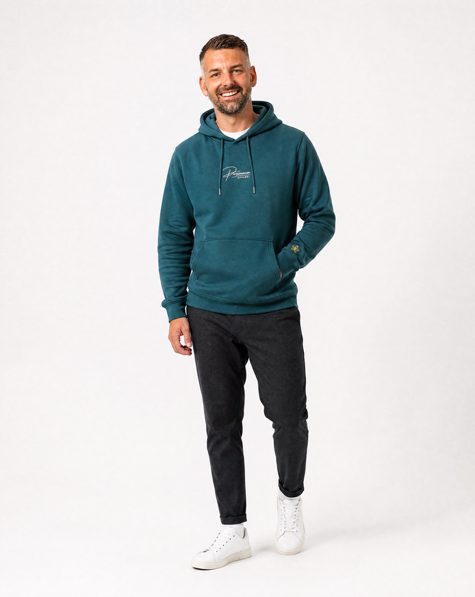 Man wearing a green hoodie with a Persimmon logo, black pants, and white shoes on a white background