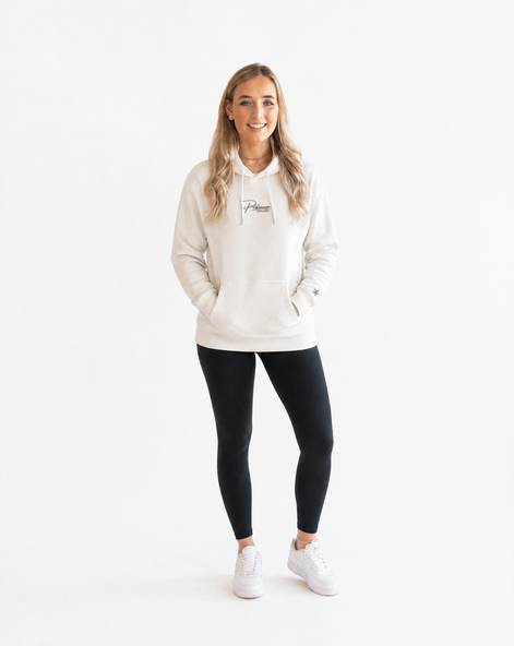 Woman wearing a cream hoodie with Persimmon logo, black leggings, and white trainers on a white background